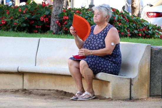 Una dona fent-se vent amb un ventall. Foto: ACN.