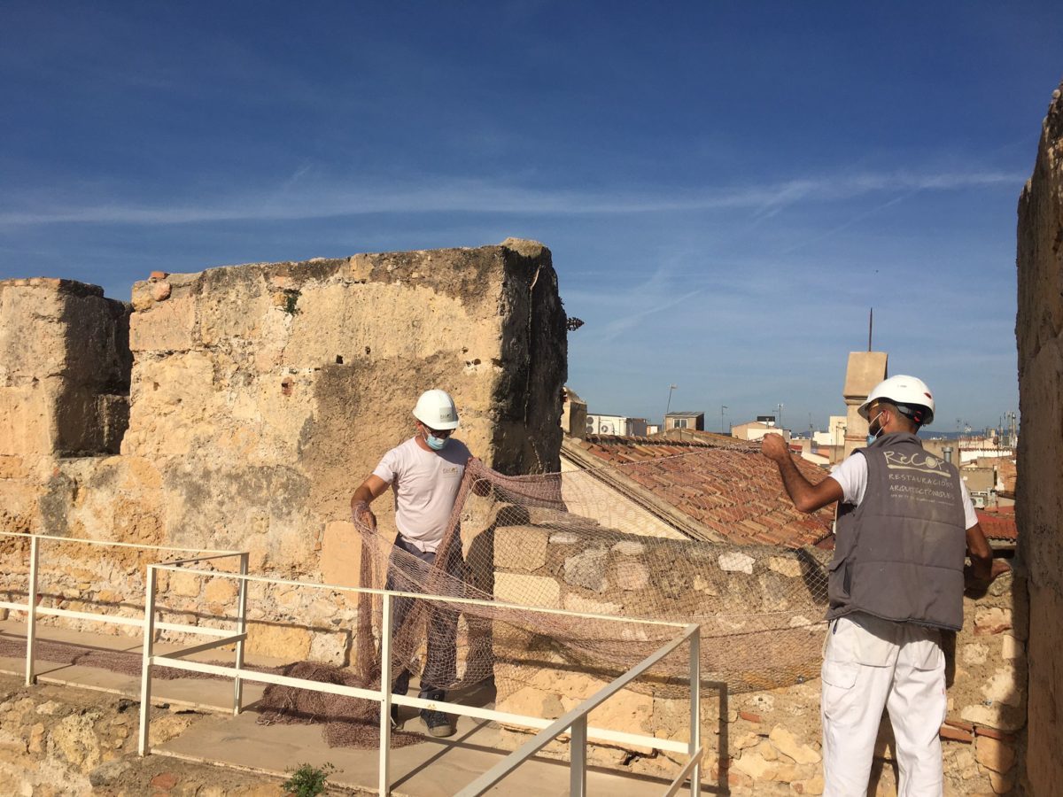 dos operaris instal·len una xarxa a la torre del pretori