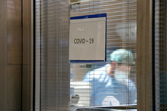 Cartell a un box d'UCI que indica que a dins hi ha un pacient covid. Foto: ACN.