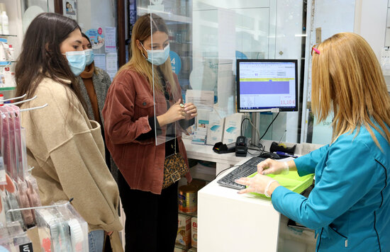 Diverses noies esperant el torn per fer-se un test d'antígens en una farmàcia. Foto: ACN.