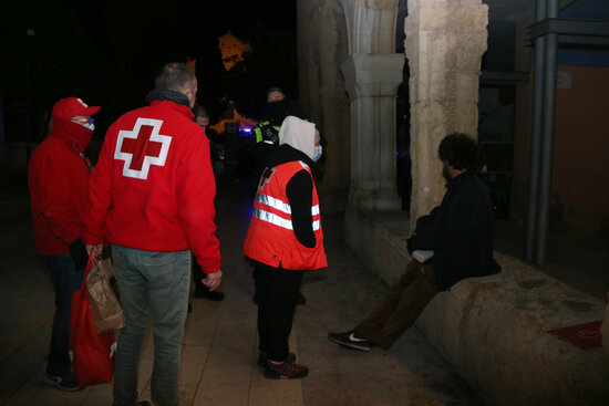 Voluntaris de Creu Roja atenent un sensesostre durant l'Operació Iglú de Tarragona.