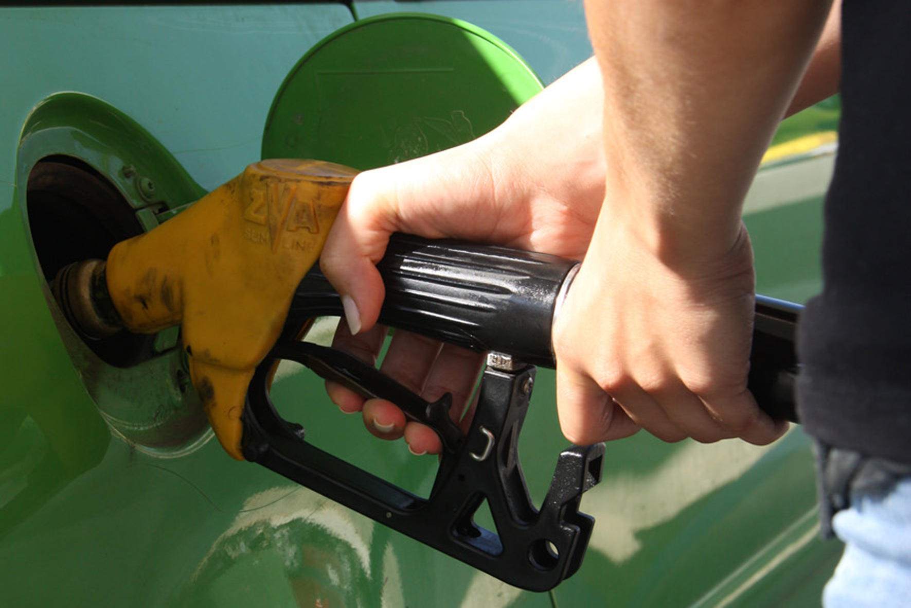 Primer pla d'un conductor posant benzina el seu vehicle