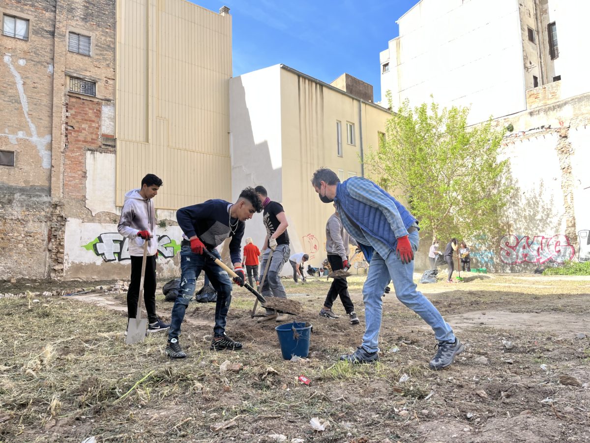 Joves del projecte i veïns del barri treballen en l'adequació del solar.